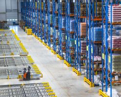 Distribution warehouse building interior and large storage area with goods on the shelf.